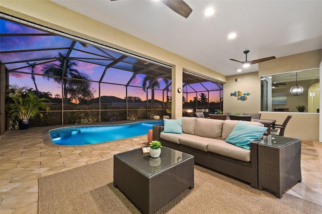 pool at dusk featuring ceiling fan