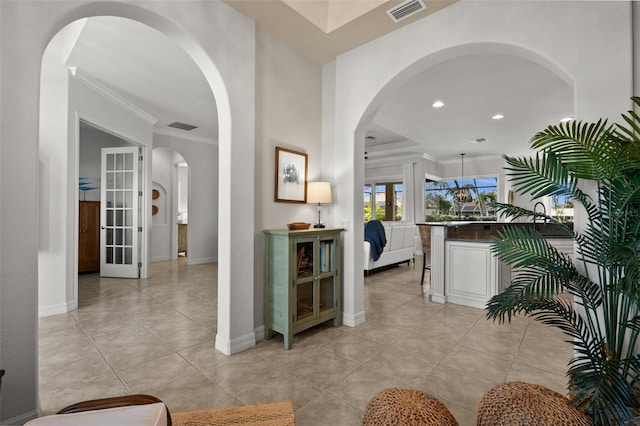 hallway with light tile patterned floors and ornamental molding