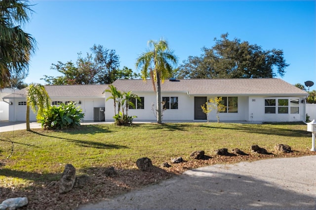 single story home featuring a front yard, concrete driveway, an attached garage, and stucco siding