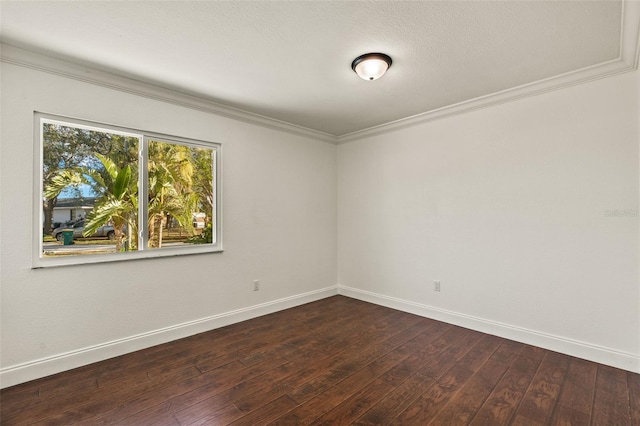 spare room featuring baseboards, dark wood-style flooring, and crown molding