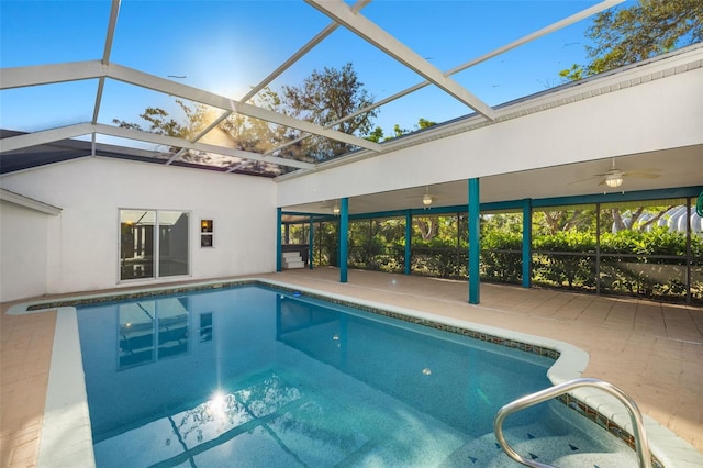 outdoor pool featuring glass enclosure and a patio