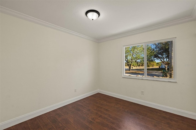 empty room with crown molding, dark wood-style flooring, and baseboards