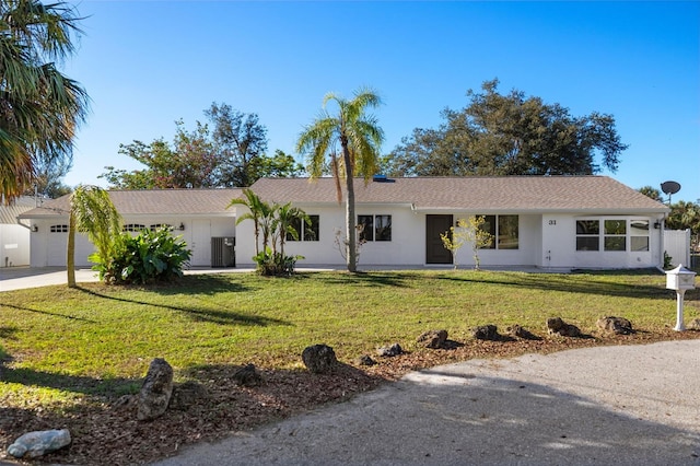 single story home with driveway, stucco siding, an attached garage, and a front yard