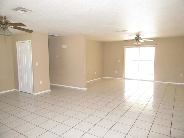 spare room featuring light tile patterned floors, a textured ceiling, and ceiling fan