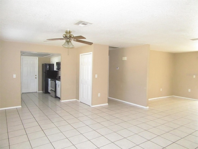 unfurnished room featuring ceiling fan, light tile patterned flooring, and a textured ceiling