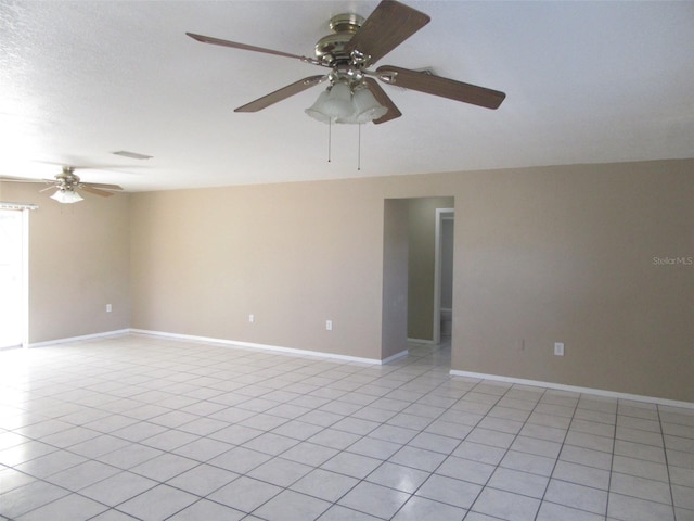 spare room with ceiling fan and light tile patterned flooring