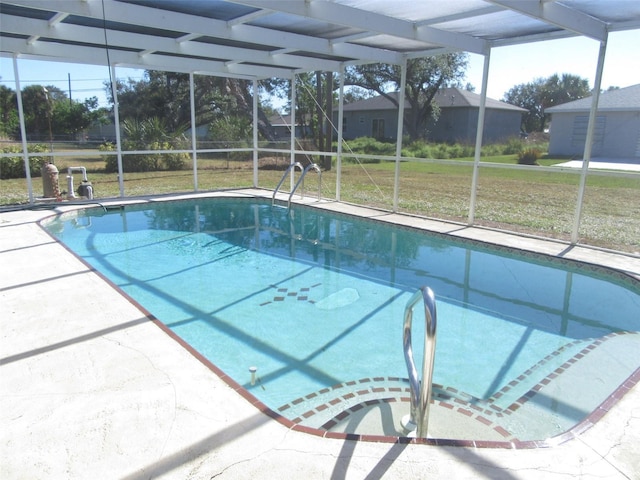 view of swimming pool featuring a lawn, glass enclosure, and a patio