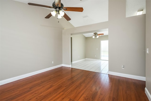 spare room with ceiling fan, light wood-type flooring, a textured ceiling, and lofted ceiling