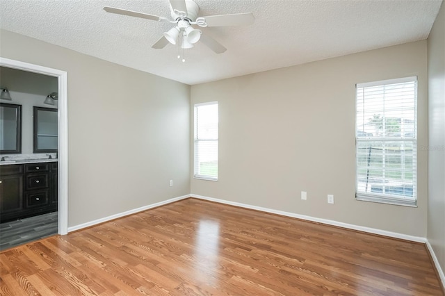 unfurnished bedroom featuring multiple windows, ceiling fan, and hardwood / wood-style floors