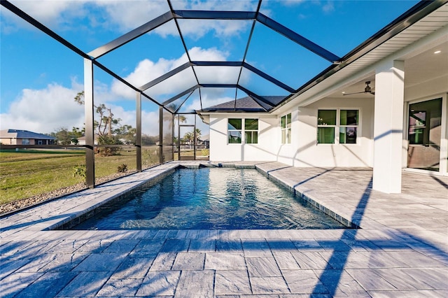 view of swimming pool featuring ceiling fan, a yard, a lanai, and a patio