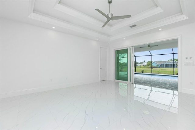 spare room featuring a raised ceiling and ceiling fan