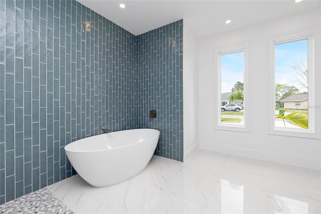 bathroom featuring tile walls and a tub