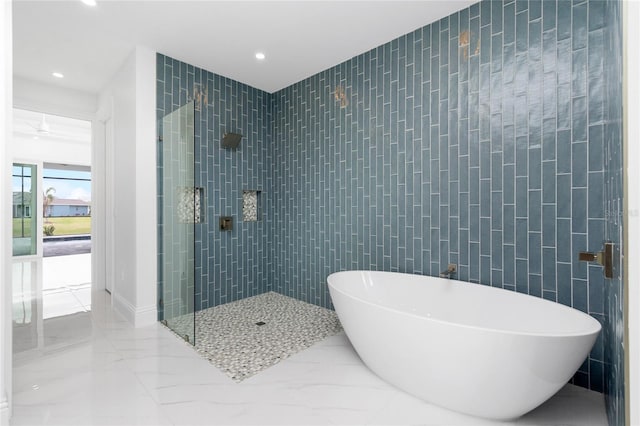 bathroom featuring tile walls and independent shower and bath