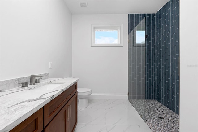 bathroom with vanity, a tile shower, and toilet