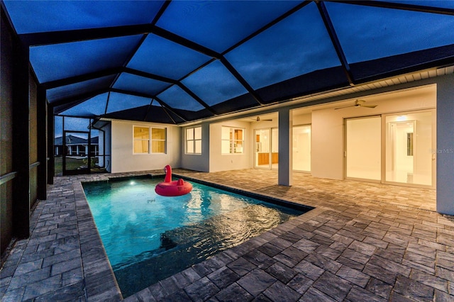 view of pool with a patio area, ceiling fan, and glass enclosure