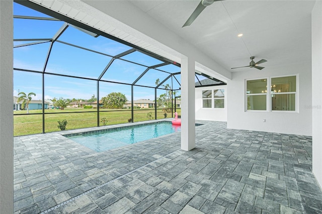 view of pool featuring ceiling fan, a yard, a patio area, and glass enclosure