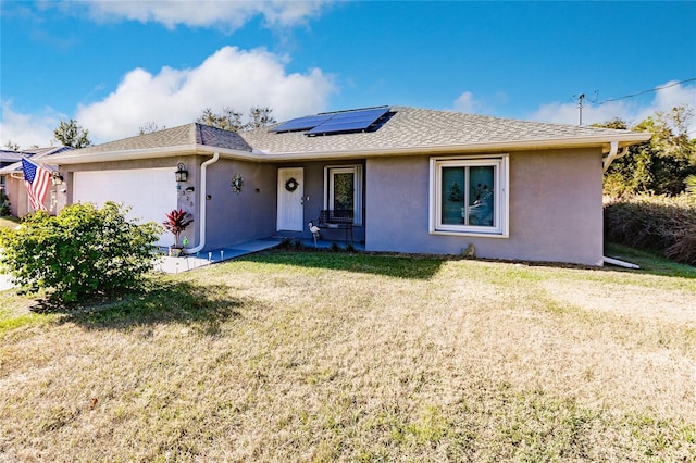 single story home with a front lawn, a garage, and solar panels