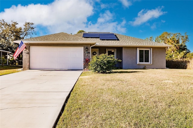 ranch-style home with a front yard, solar panels, and a garage