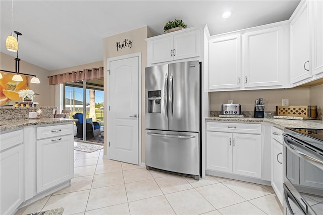 kitchen with lofted ceiling, light tile patterned flooring, white cabinetry, and stainless steel appliances