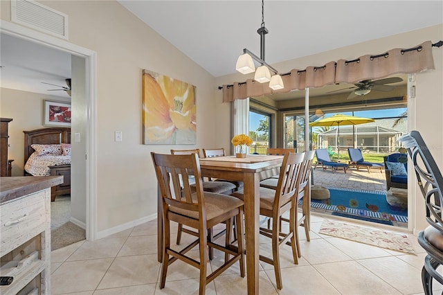 dining area with ceiling fan, light tile patterned flooring, and vaulted ceiling