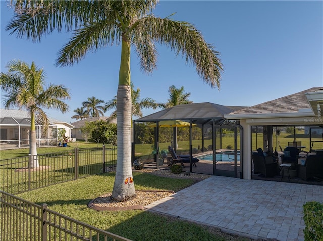 view of yard with a fenced in pool, glass enclosure, and a patio