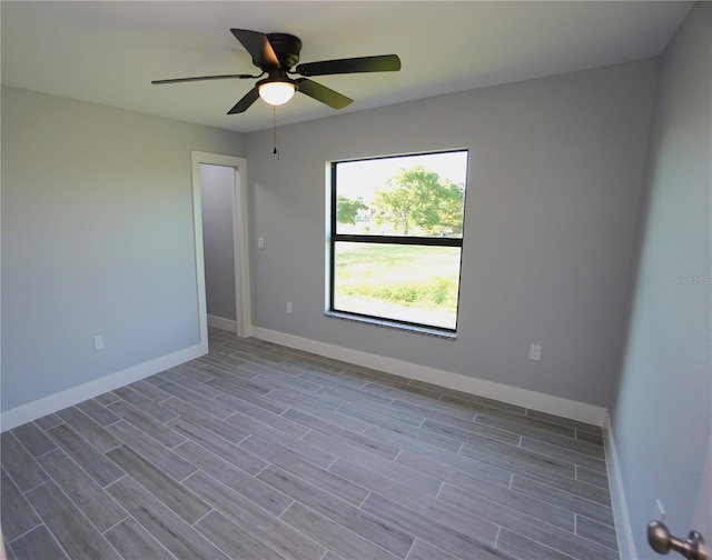 unfurnished room with ceiling fan, baseboards, and wood finished floors