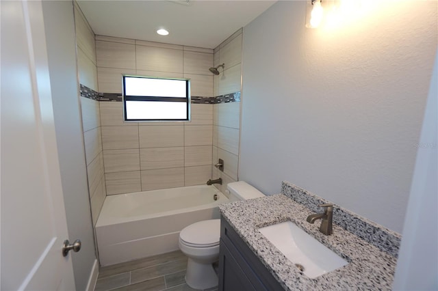 full bathroom with vanity, tiled shower / bath combo, and toilet