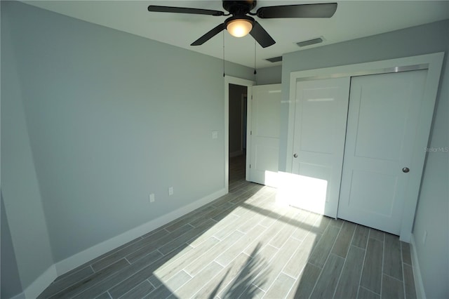 unfurnished bedroom with ceiling fan and a closet