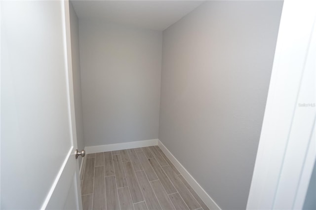 interior space featuring baseboards and wood tiled floor