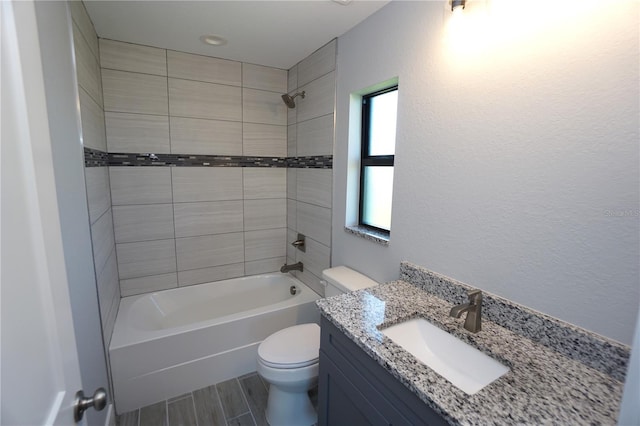 full bathroom featuring wood tiled floor, toilet, shower / bathtub combination, a textured wall, and vanity