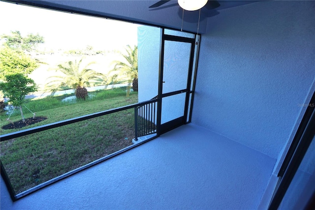 unfurnished sunroom featuring ceiling fan