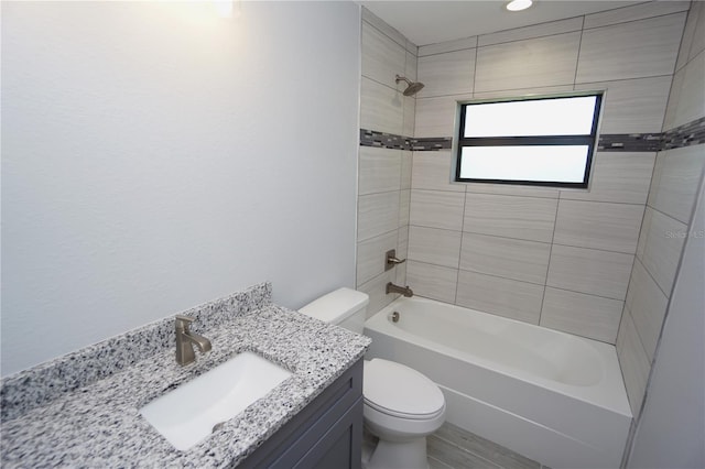 full bathroom with tiled shower / bath combo, toilet, and vanity