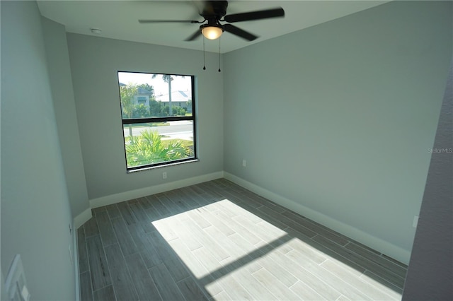 empty room featuring ceiling fan, baseboards, and wood tiled floor