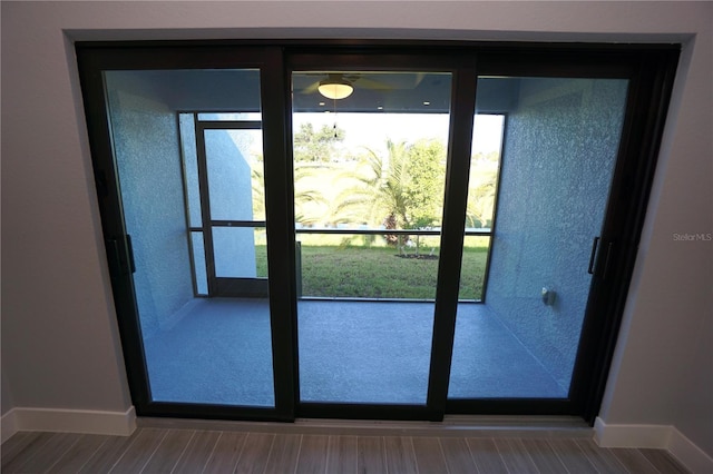 doorway featuring wood finished floors and baseboards