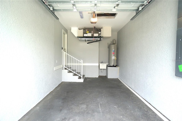 garage featuring a sink, water heater, and a textured wall