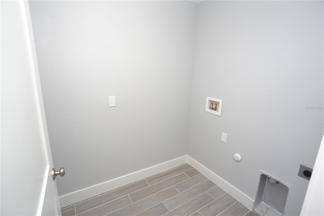 laundry area featuring baseboards, wood tiled floor, laundry area, electric dryer hookup, and washer hookup