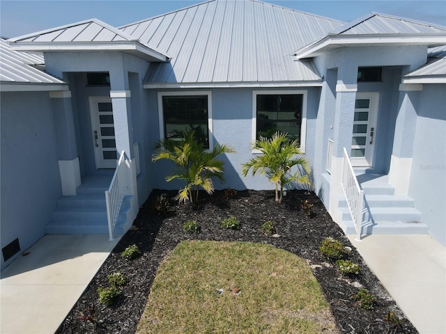 view of front of property with stucco siding, metal roof, and a standing seam roof