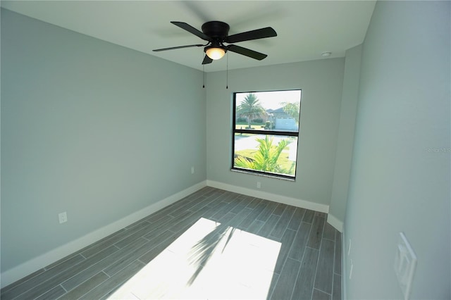 empty room featuring ceiling fan, baseboards, and wood finish floors