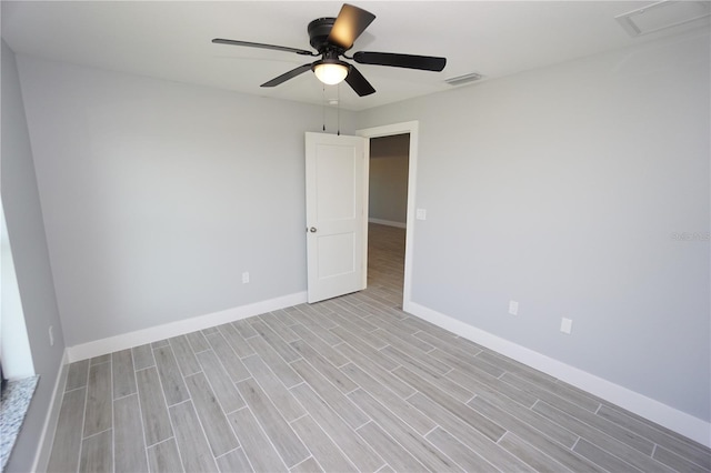 unfurnished room featuring wood finish floors, visible vents, baseboards, and ceiling fan