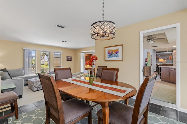 tiled dining room featuring a chandelier