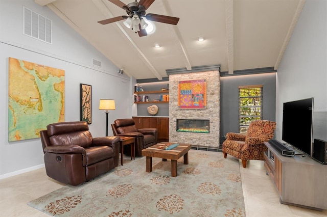 living room featuring built in shelves, ceiling fan, a stone fireplace, and vaulted ceiling with beams