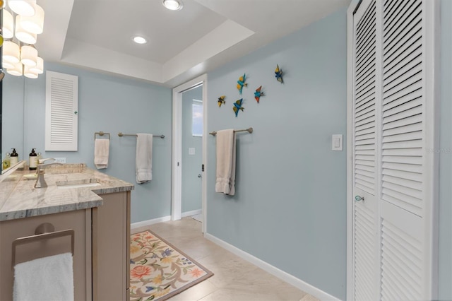 bathroom featuring vanity, a tray ceiling, and tile patterned floors