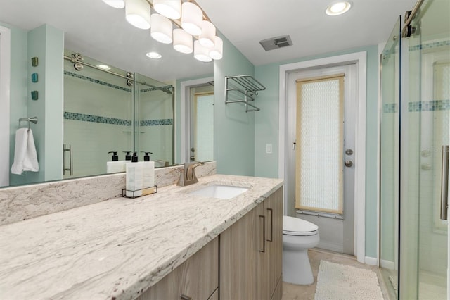 bathroom featuring vanity, toilet, and an enclosed shower