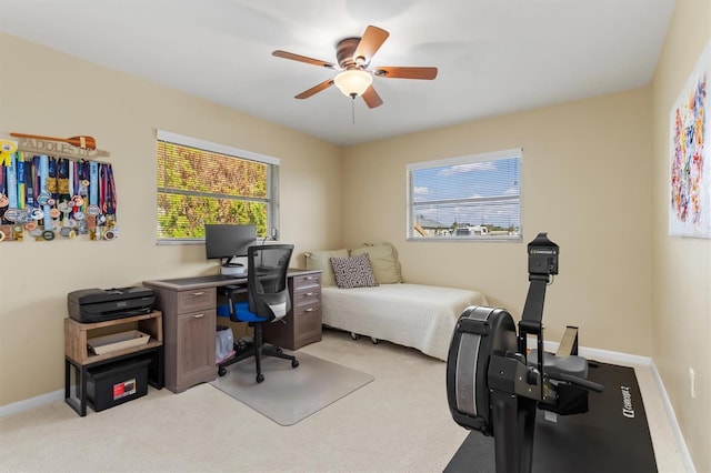 carpeted home office featuring ceiling fan