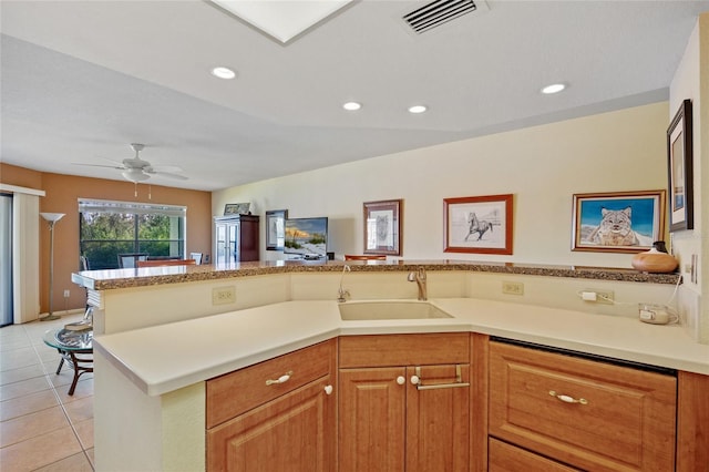 kitchen featuring kitchen peninsula, ceiling fan, sink, and light tile patterned floors