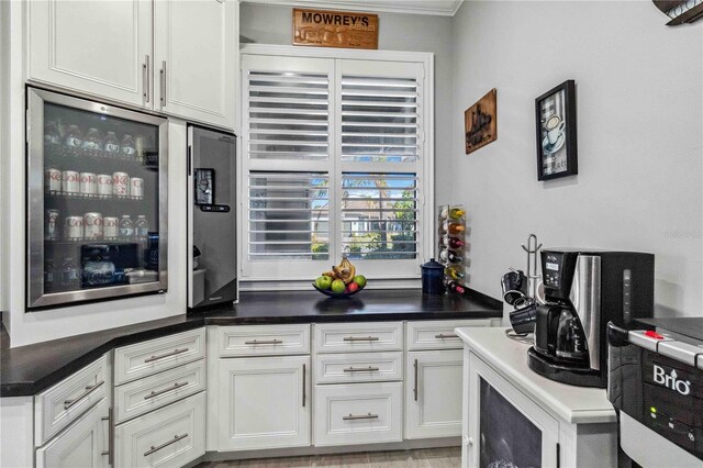 kitchen with white cabinetry, light hardwood / wood-style flooring, and ornamental molding