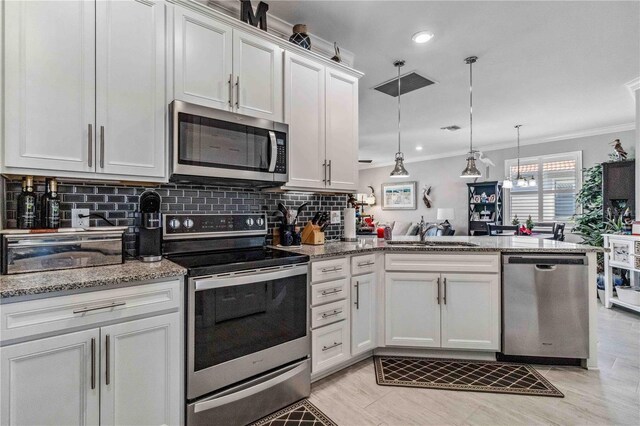 kitchen featuring kitchen peninsula, appliances with stainless steel finishes, white cabinets, and sink