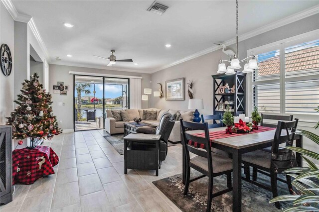 dining space featuring ceiling fan with notable chandelier, plenty of natural light, and ornamental molding