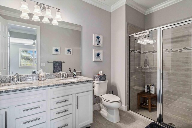 bathroom with vanity, toilet, ornamental molding, and walk in shower