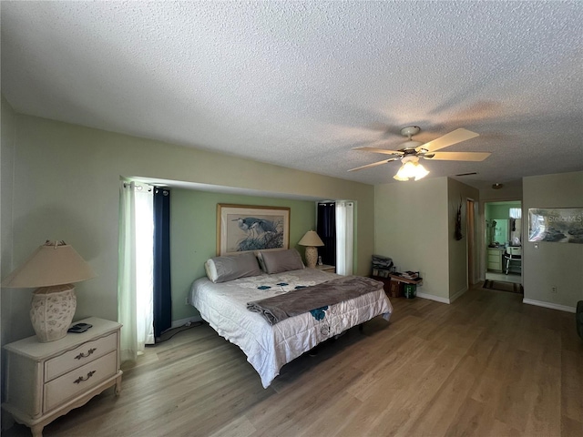 bedroom featuring ceiling fan, light wood-type flooring, and a textured ceiling